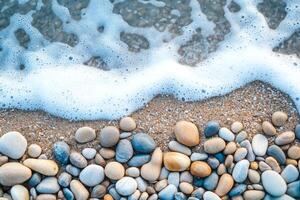 Beach stones with waves and foam on the shoreline. photo