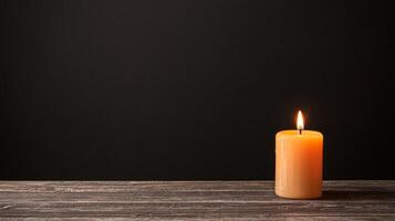 Candle glowing softly on a dark background with wooden surface. photo