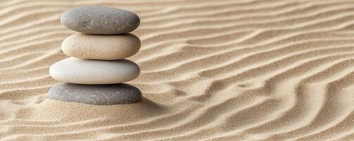 Stacked stones on textured sand create a calming, minimalist scene. photo