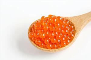 Bright orange fish roe in a wooden spoon on a white background. photo