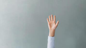 Hand raised against a muted gray background. Communication skills persuasion. photo