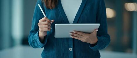 Person holding a tablet and stylus in a modern setting. photo
