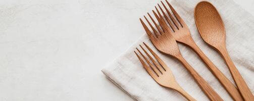 Wooden cutlery on a gray linen napkin against a light background. photo