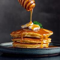 Stack of pancakes topped with syrup and a pat of butter. photo