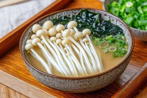Delicious soup with mushrooms and seaweed in a textured bowl. photo