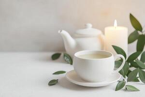 A serene tea setup with a candle and greenery accents. photo