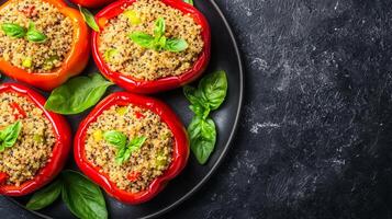 Stuffed bell peppers garnished with basil on a dark plate. photo