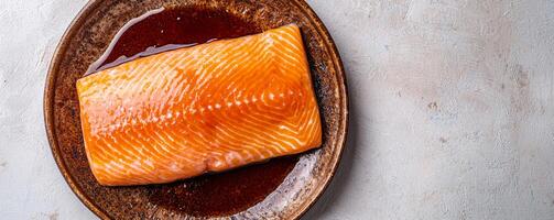 Fresh salmon fillet on a textured plate ready for cooking. photo
