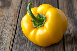 Bright yellow bell pepper on rustic wooden surface. photo