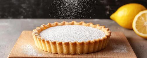 Lemon tart dusted with powdered sugar on a wooden surface. photo