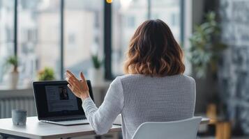 Woman communicating via laptop in a modern workspace. photo