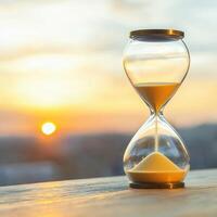 Hourglass against a sunset background symbolizing time. Time management work life balance motivation. photo
