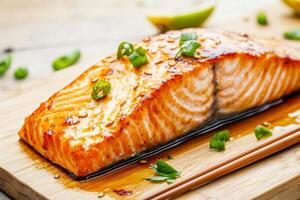 Freshly cooked salmon fillet garnished with herbs on a wooden board. photo