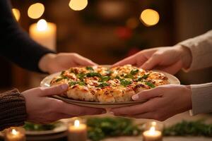 Warm hands sharing a festive dish with soft candlelight ambiance. photo