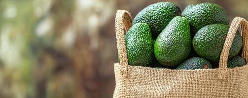 Fresh avocados in a burlap bag, ready for market sale. photo