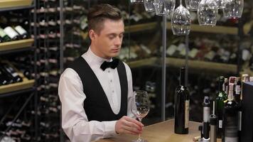 Sommelier skillfully examining wine while elegantly poised at a wooden table video