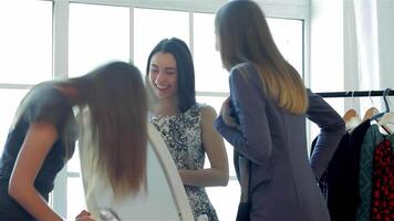 Girlfriends joyfully trying on new clothes in front of a mirror video