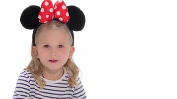 Curious little girl with a playful expression on a bright white background video