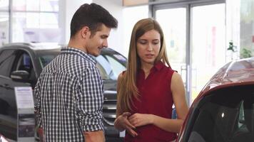 Young couple exploring car options at the dealership video