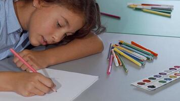 Joyful little girl immersed in creativity while drawing in her sketchbook video