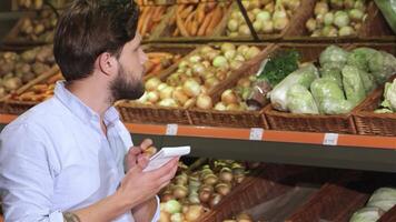 Thoughtful man jotting down notes in his notebook at the supermarket video