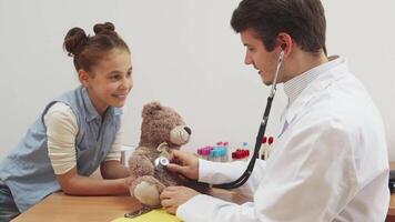 A little girl brings her teddy bear to a doctor's appointment for a check-up. video