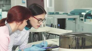 Two female biologists collaborating on experiments in a modern lab video