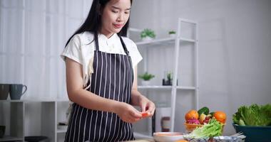 Handheld low angle view shot, Beautiful young woman in striped apron preparing ingredients for salad rolls. Healthy Cooking at Home, Cooking Concept video