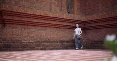 Handheld low angle view shot, Solo female tourist enjoys strolling around to appreciate the serene surroundings and the cultural richness of the place. Traveling and vacation concept video