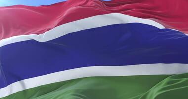 Flag of the Gambia waving at wind in slow in blue sky, loop video