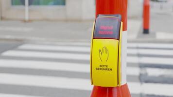 Traffic rules. A pedestrian presses a traffic light button to cross the road. A yellow button on a traffic light to activate the green light of the traffic light at a pedestrian crossing. video