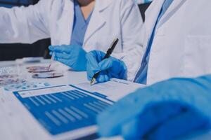 Two doctors in lab coats and gloves are working on a document photo