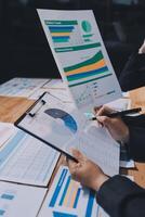Businessman using a clipboard to write on a paper with graphs photo