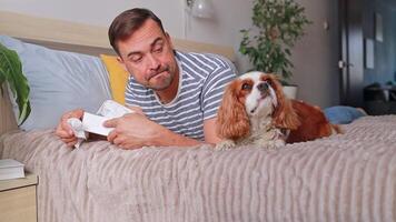 close up man suffering from allergy and sneezing near dog lying on bed. he uses paper tissues. health concept, veterinarian, allergist. video