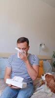 man pulls out tissues and sneezes heavily beside a dog, struggling with allergic reactions to fur. concept by pet grooming, allergy medications, animal shelters. video