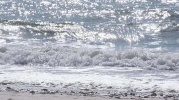 Sparkling ocean waves gently crashing on the shore in portugal video