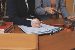 Two business people sitting at a desk with a notebook and a gavel photo
