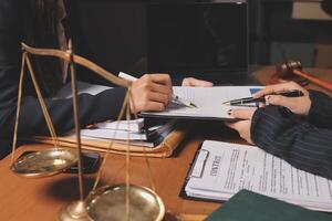 Two lawyers at a desk with a scale and a pen photo