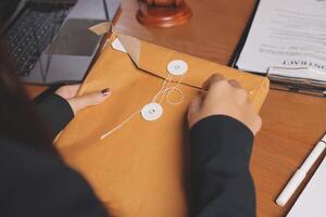 A woman is holding a brown envelope with a paper tag photo