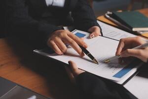 Two business people signing documents on a desk photo