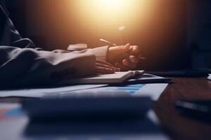 Businessman writing on paper with light shining on him photo