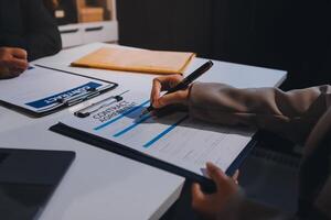 A business person signing a document on a table photo