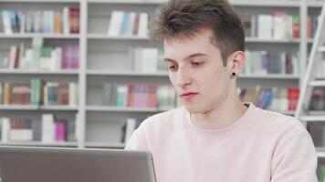 Smiling young male student engaged in study at the library video