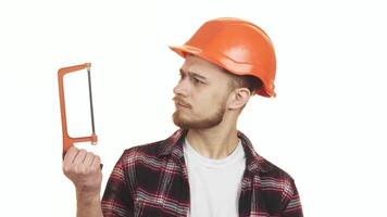 Young handyman thoughtfully selecting between two saws for his next project video