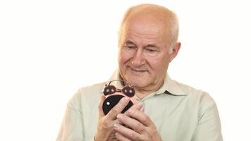 Cheerful senior man smiling at the camera while holding an alarm clock video