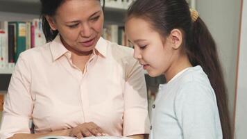 Mother and daughter joyfully exploring books together at the library video