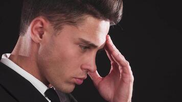 Intense close-up of a handsome man stroking his forehead video