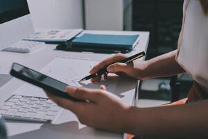A person is using a pen and a phone to write on a piece of paper photo