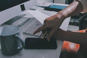 A person is typing on a keyboard and holding a cup of coffee photo