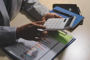 A man is using a calculator to calculate the value of a business photo